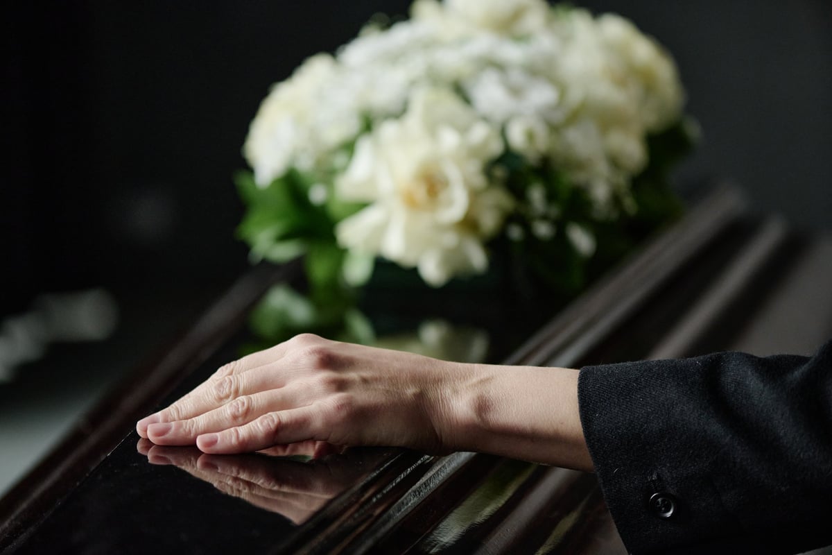 Dignified funeral ceremony with white flowers and closed coffin